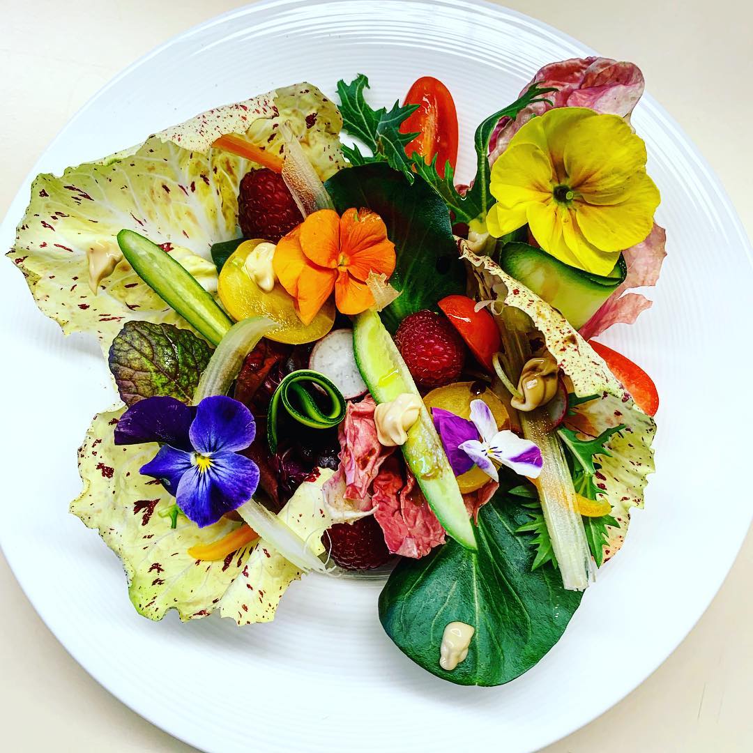 Colorful composed salad plate with edible flowers.